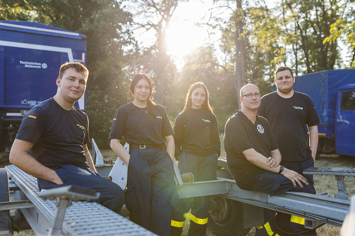 THW Team ruht sich im Sonnenlicht der untergehenden Sonne nach dem Einsatz aus