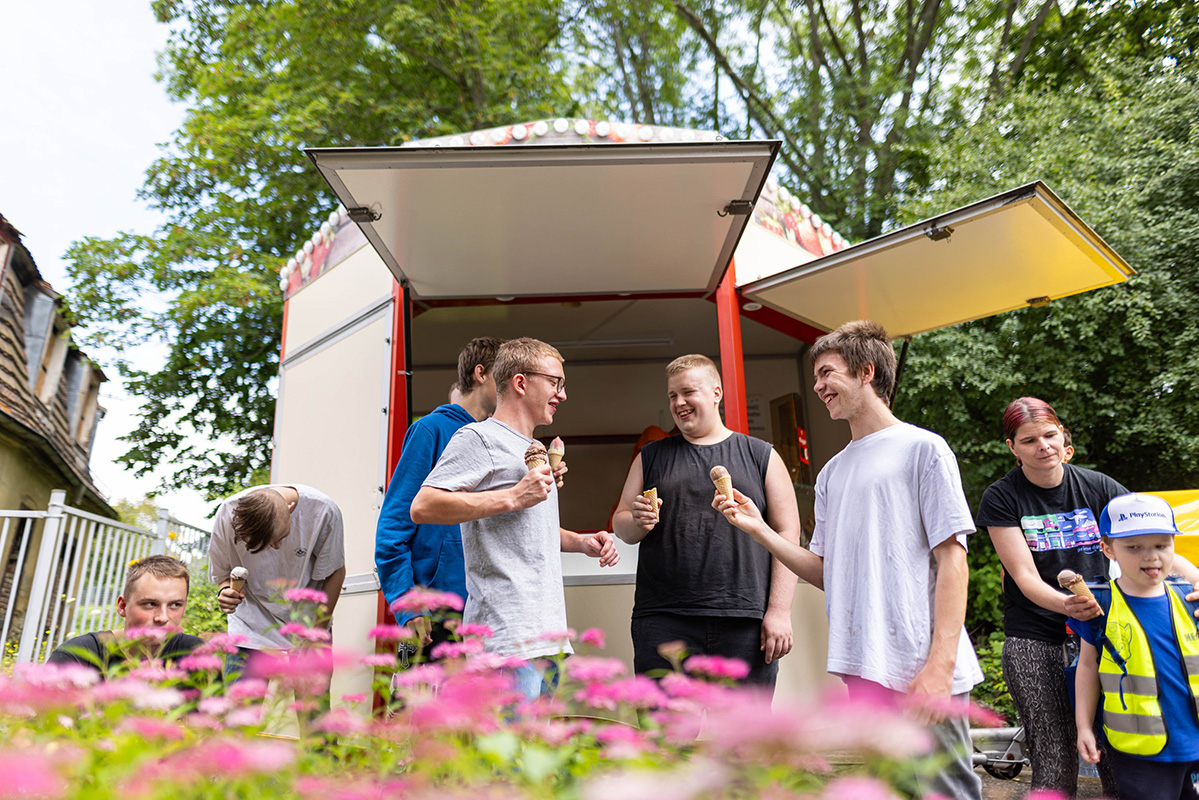 Junge Männer holen sich ein Eis an einem kleinen Eiswagen