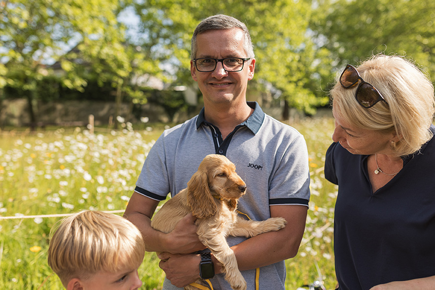 Herr Meinhardt von den Stadtwerken Weißenfels mit Babyhund auf dem Arm